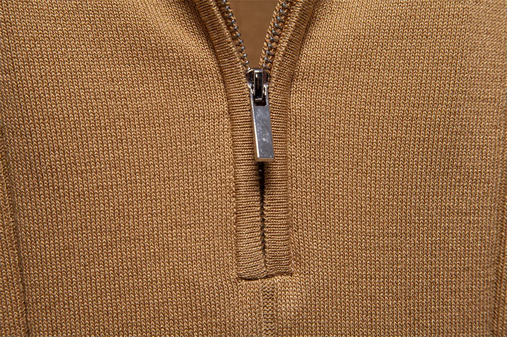 Close-up of a brown textured fabric with a silver zipper pull.