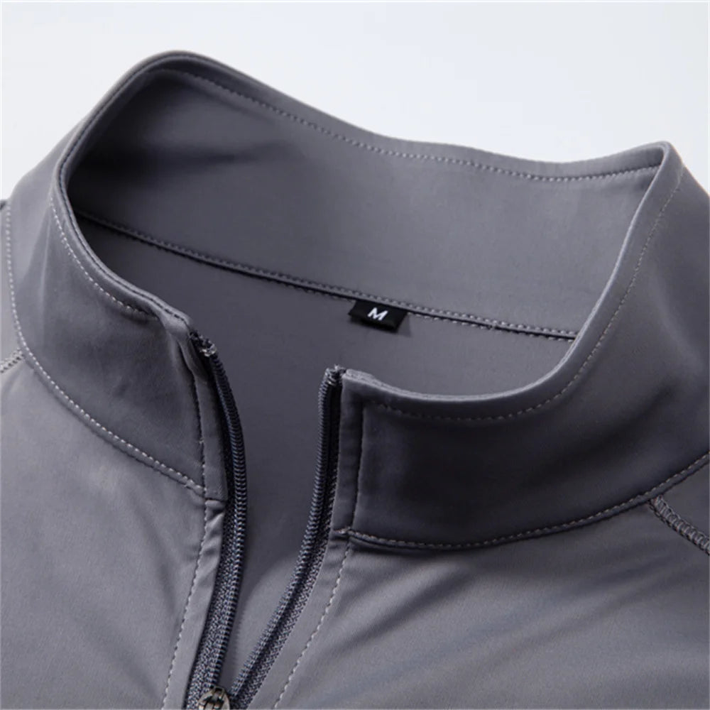 Close-up of a gray jacket with a zipper and brand logo on a light gray background