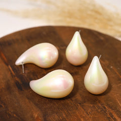 Four pearl earrings on a wooden surface