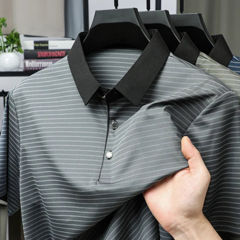 Gray striped polo shirt with black collar held by a hand on a blurred background